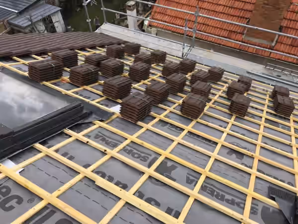 Liteaunage neuf et paquets de tuiles répartis sur le versant avant couverture